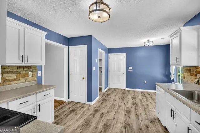 a spacious bathroom with a granite countertop sink a mirror and a shower