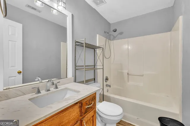 a bathroom with a granite countertop sink toilet and shower