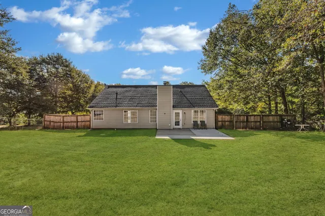 a backyard of a house with table and chairs