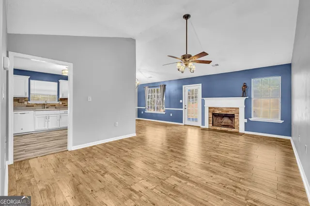 a view of empty room with wooden floor and fireplace