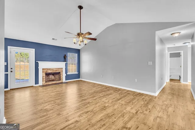 a view of an empty room with a window and fireplace