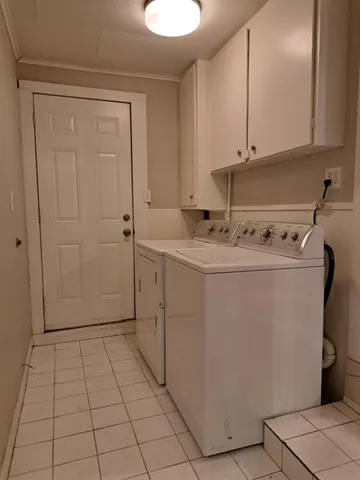 a utility room with cabinets washer and dryer