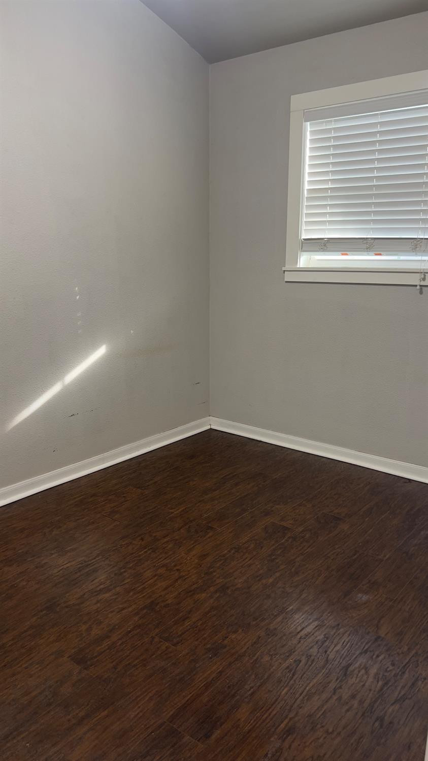 2714 29th Street Lubbock, TX 79410 - Photo 18 of 20 a view of an empty room with wooden floor and a window