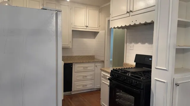 a kitchen with granite countertop a refrigerator and a stove