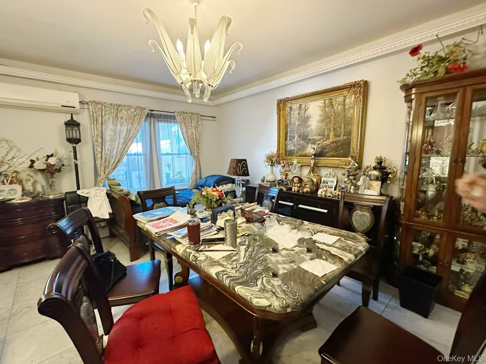 28-07 172nd Street Queens, NY 11358 - Photo 3 of 10 Dining space with crown molding, a chandelier, an AC wall unit, and light tile patterned floors