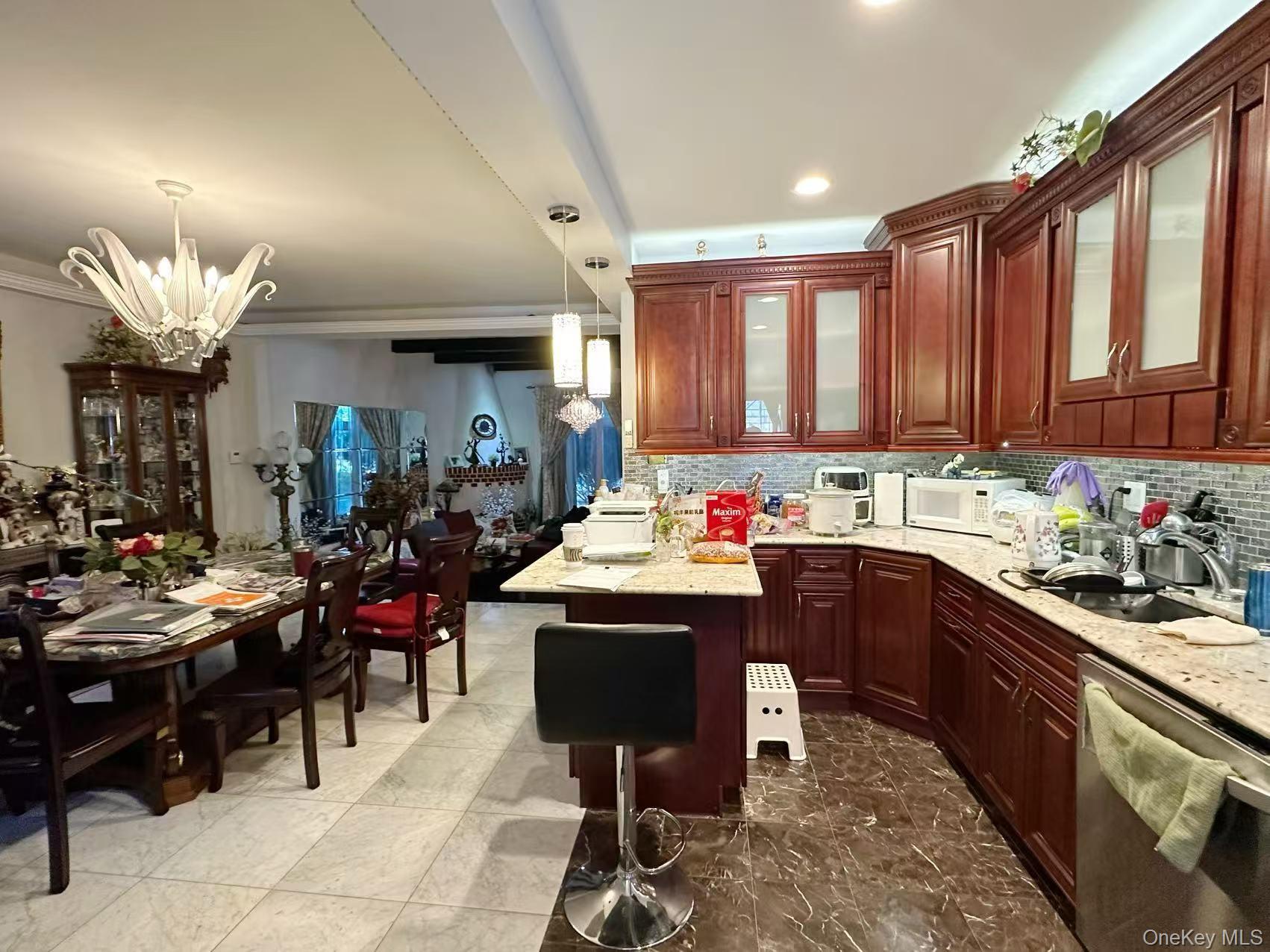 28-07 172nd Street Queens, NY 11358 - Photo 4 of 10 Kitchen with dishwasher, backsplash, pendant lighting, light stone counters, and white microwave