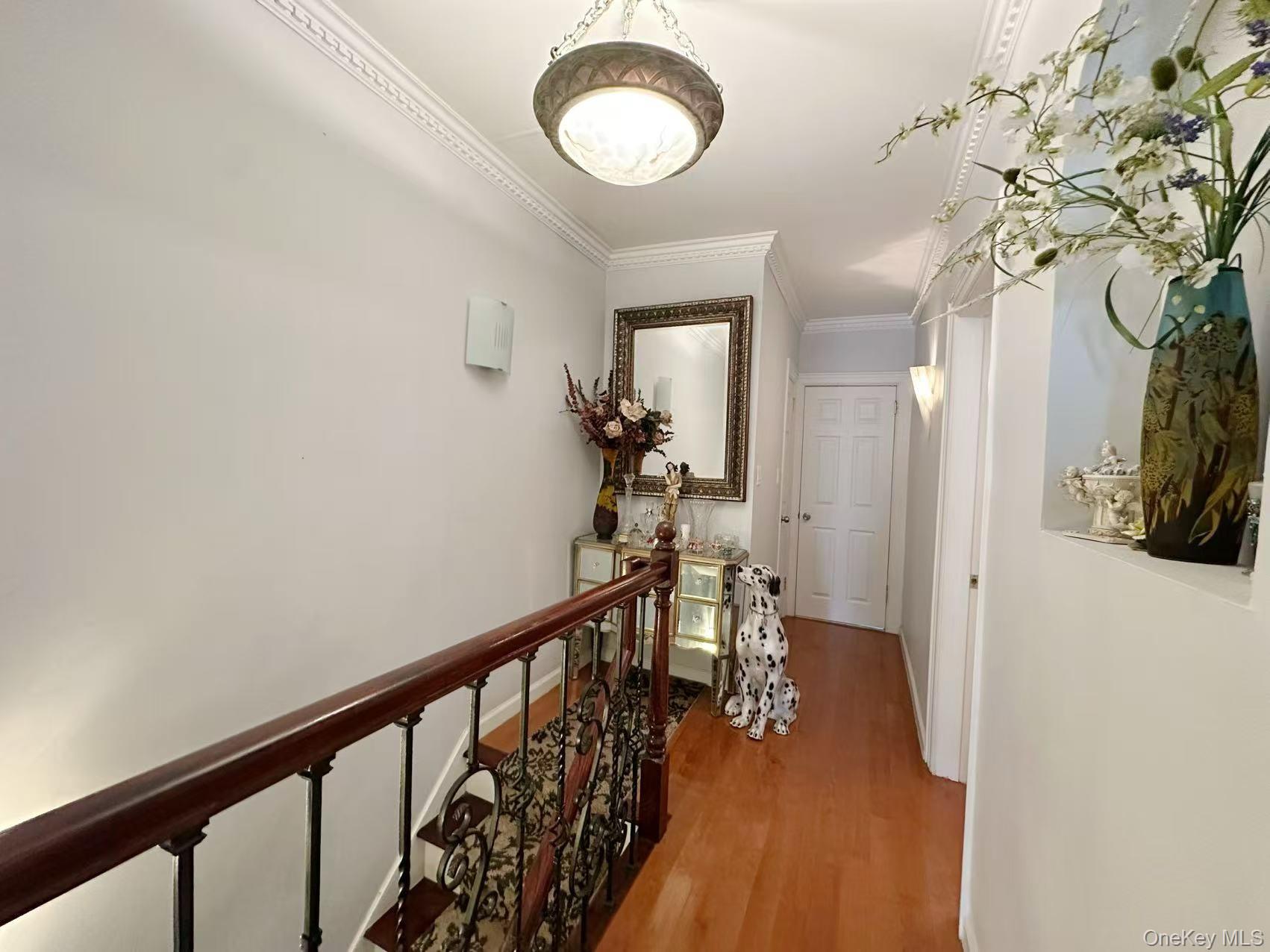 28-07 172nd Street Queens, NY 11358 - Photo 5 of 10 Hallway with crown molding, light wood-style flooring, and an upstairs landing
