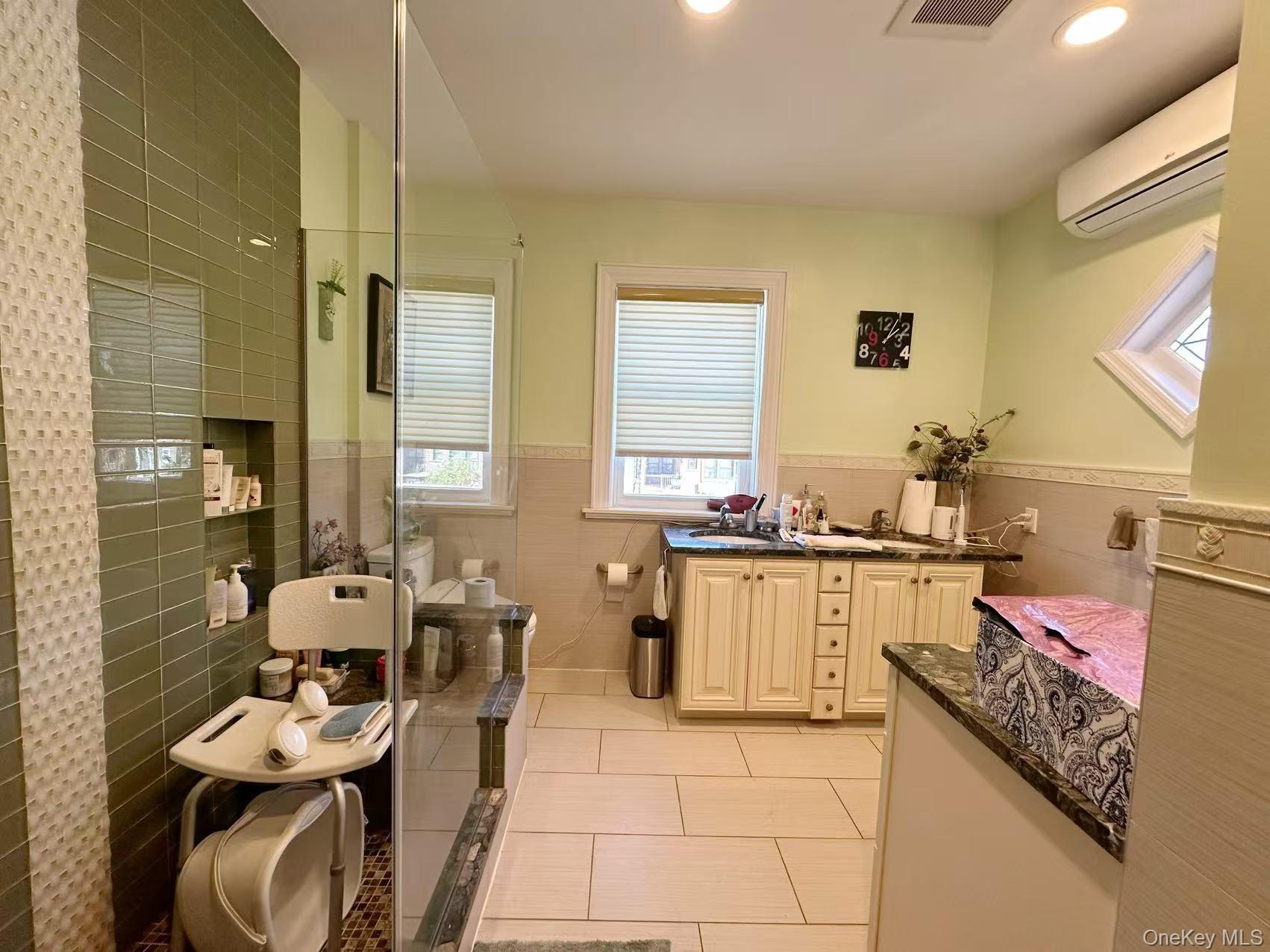 28-07 172nd Street Queens, NY 11358 - Photo 7 of 10 Bathroom with light tile patterned floors, a wall unit AC, vanity, recessed lighting, and plenty of natural light