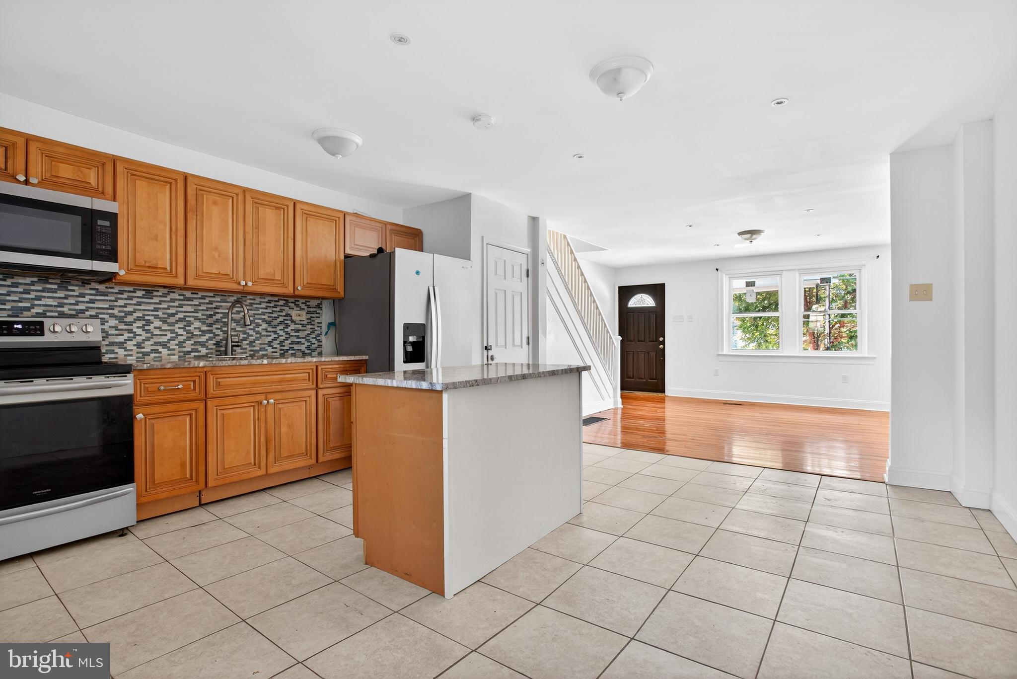 5119 Sheldon Street Philadelphia, PA 19144 - Photo 9 of 27 a kitchen with stainless steel appliances granite countertop a stove a sink and a refrigerator