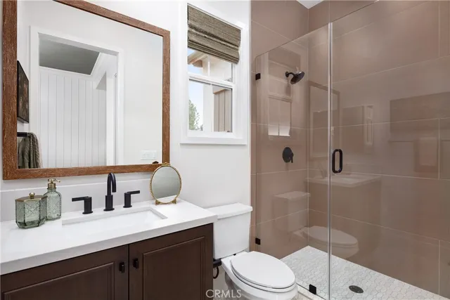 a bathroom with a sink toilet a mirror and shower