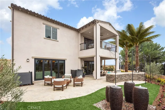 a view of a house with backyard and sitting area