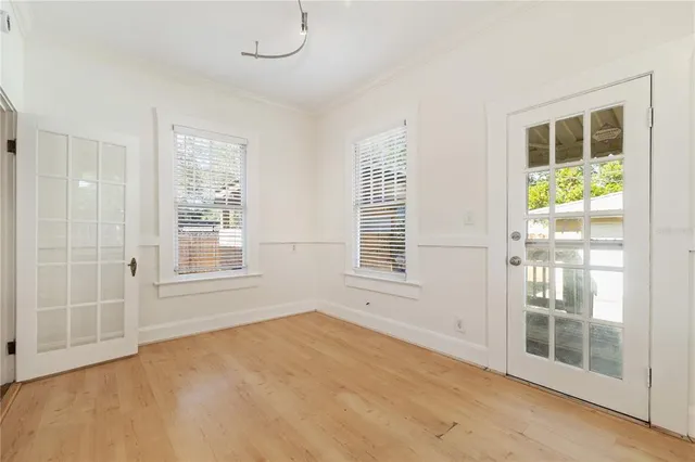 a view of an empty room with a window and wooden floor