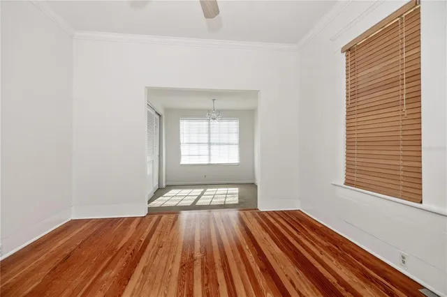 a view of a room with wooden floor and two windows