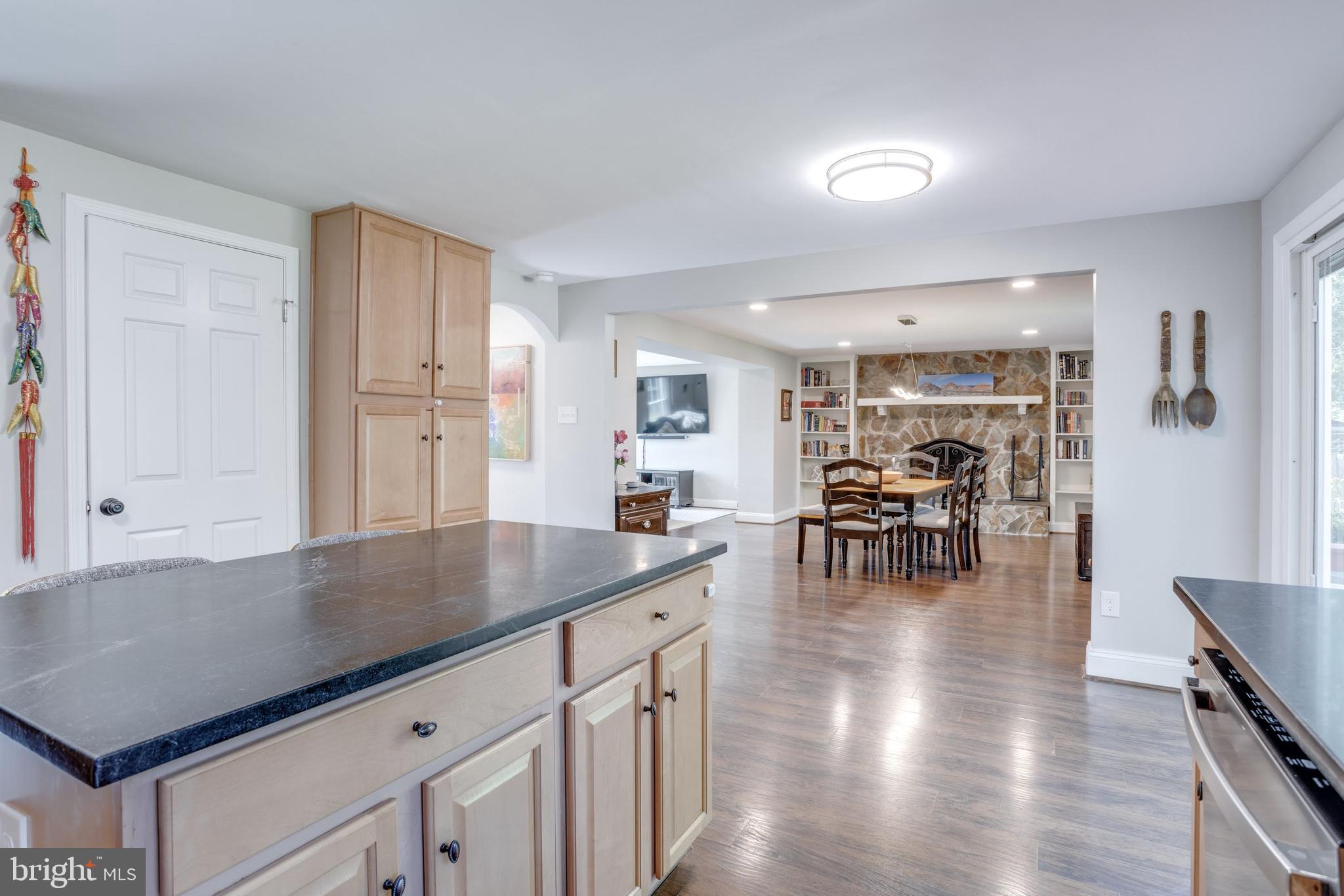 7114 Sterling Grove Drive Springfield, VA 22150 - Photo 17 of 55 a kitchen with stainless steel appliances granite countertop a table chairs and a refrigerator