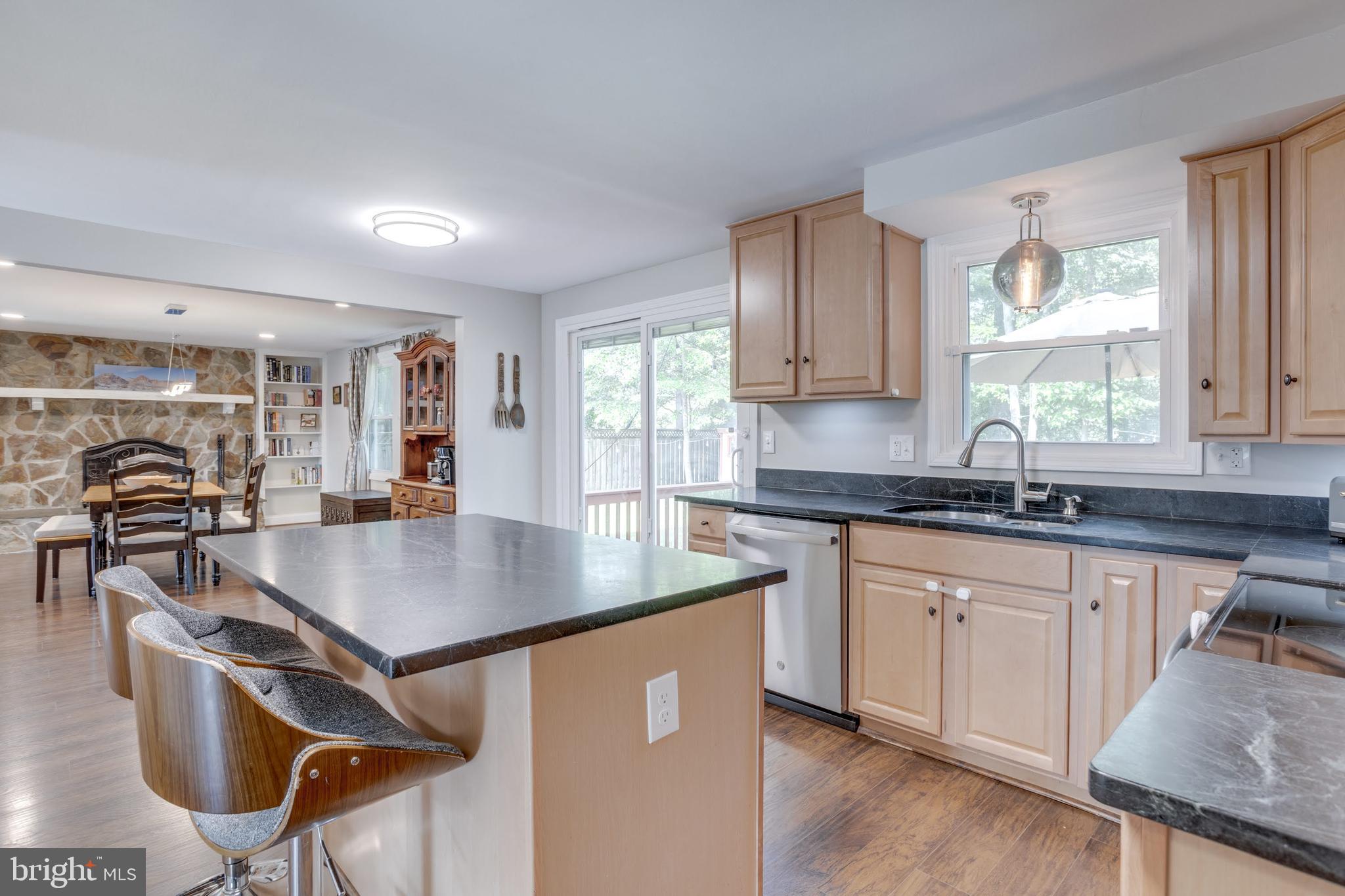 7114 Sterling Grove Drive Springfield, VA 22150 - Photo 18 of 55 a kitchen with stainless steel appliances granite countertop a sink a stove and a wooden floors