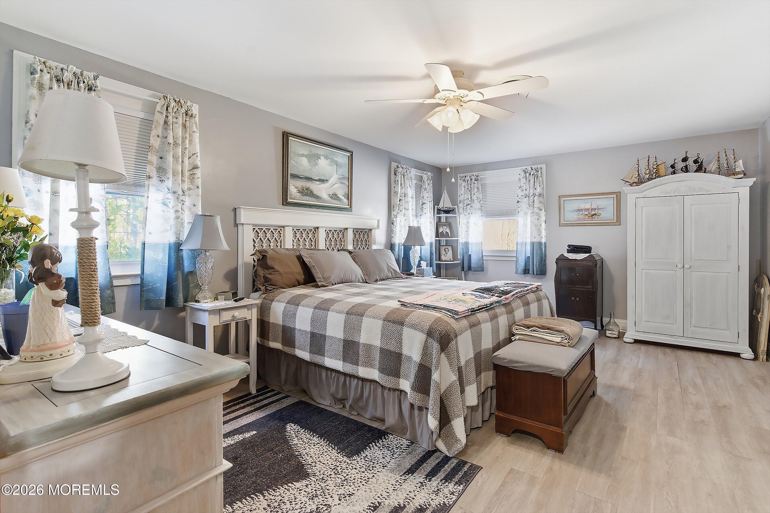 27 Amesbury Road, Unit 64 Whiting, NJ 08759 - Photo 29 of 50 a bedroom with a bed a chandelier and flat screen tv