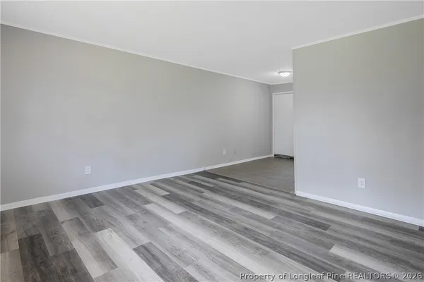 a view of empty room with wooden floor