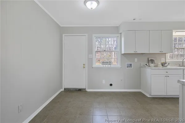 a utility room with cabinets washer and dryer