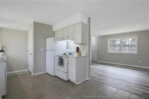 a view of empty room with window and wooden floor