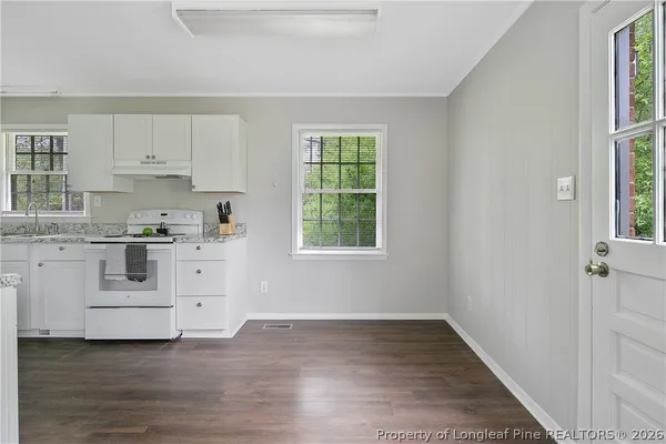 a kitchen with white cabinets and white appliances