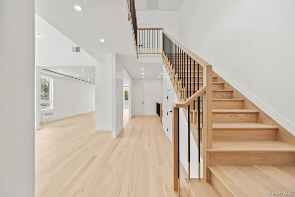 a view of a hallway with wooden floor and staircase