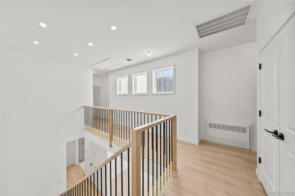 a view of a hallway with entryway and wooden floor