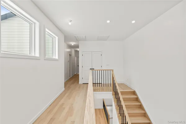 a view of a bedroom with wooden floor and stairs