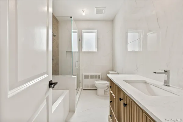 a bathroom with a sink a toilet and shower