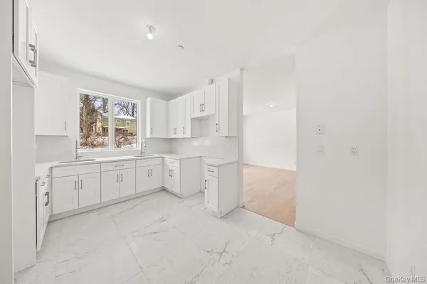 a large white kitchen with white cabinets