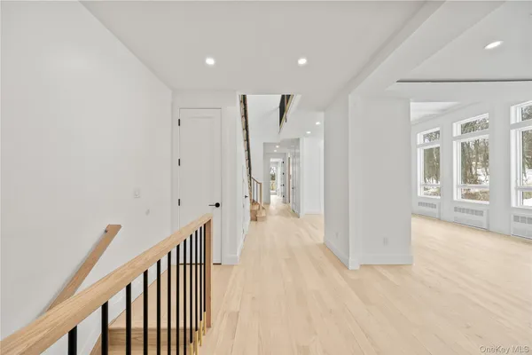 a view of a hallway with wooden floor and windows