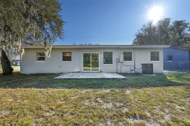 a view of a house with backyard and trees