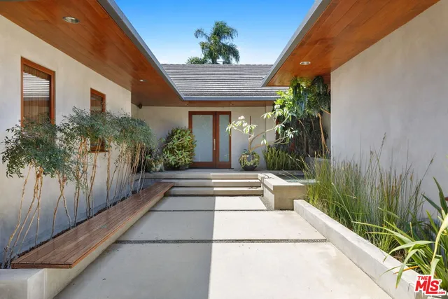 a view of a house with potted plants