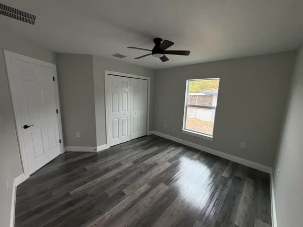 a view of an empty room with wooden floor