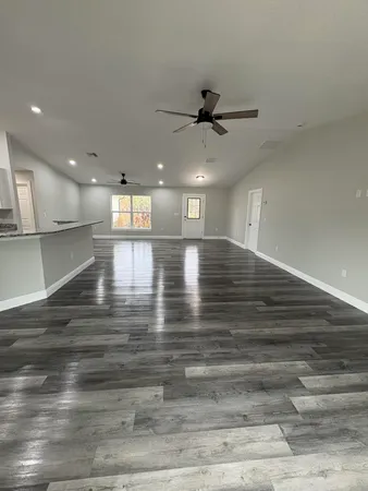a view of a room with an empty space and a ceiling fan