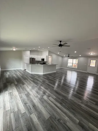 a view of a room with kitchen island a sink wooden floor and living room view