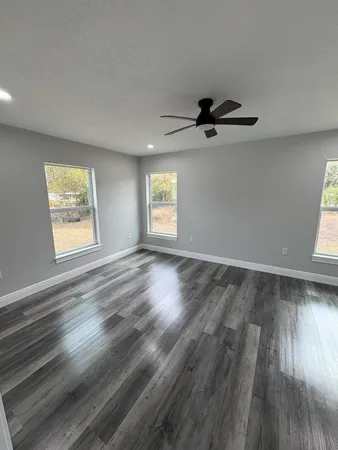 wooden floor in an empty room with a window
