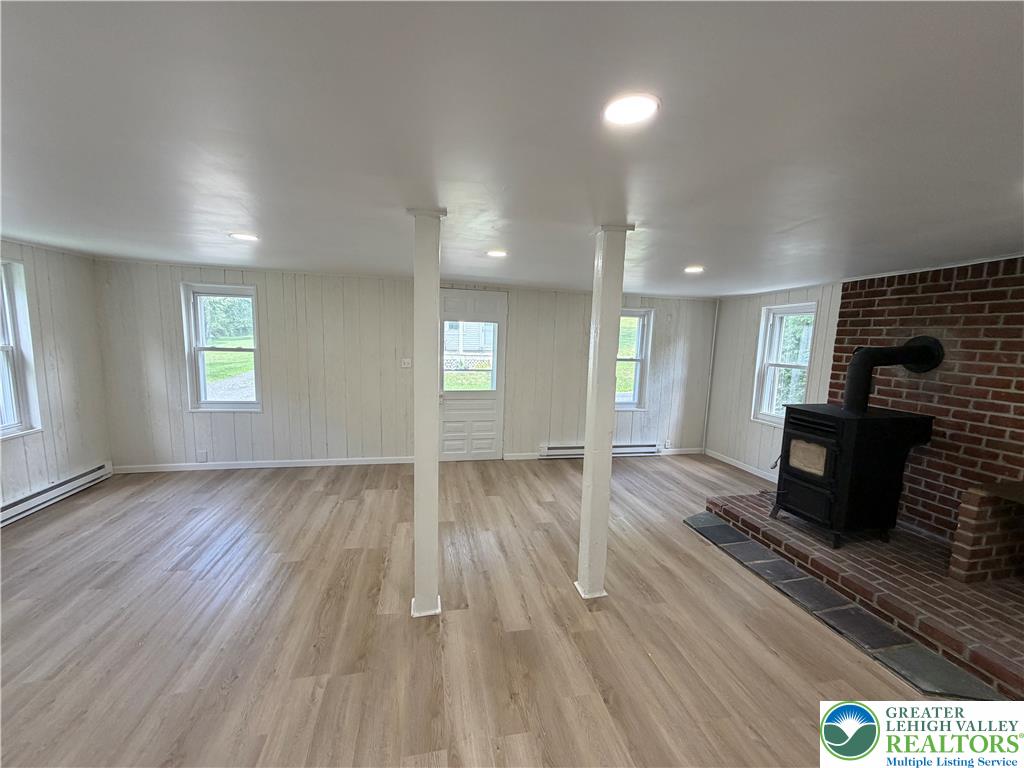 5720 Memorial Road Germansville, PA 18053 - Photo 8 of 29 A welcoming living space features light wood-look flooring and a classic brick fireplace.
