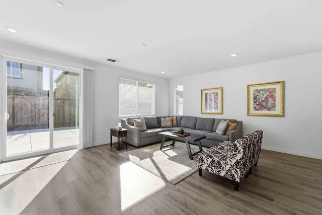 a living room with furniture wooden floor and a large window