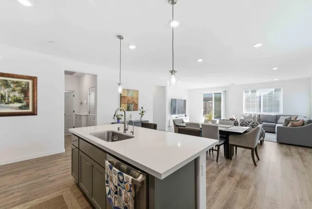 a view of a dining room and livingroom with furniture wooden floor a chandelier