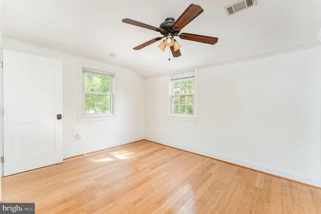 an empty room with a window and a fan
