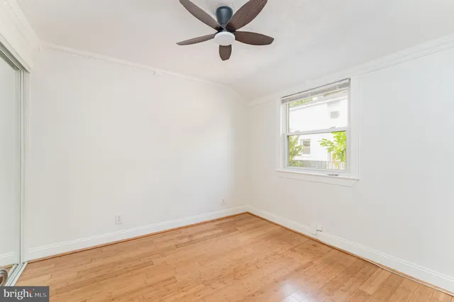 an empty room with a window and a fan