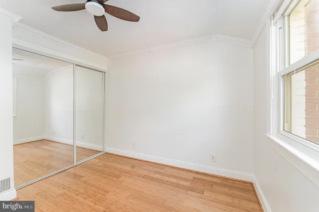 an empty room with fan and windows