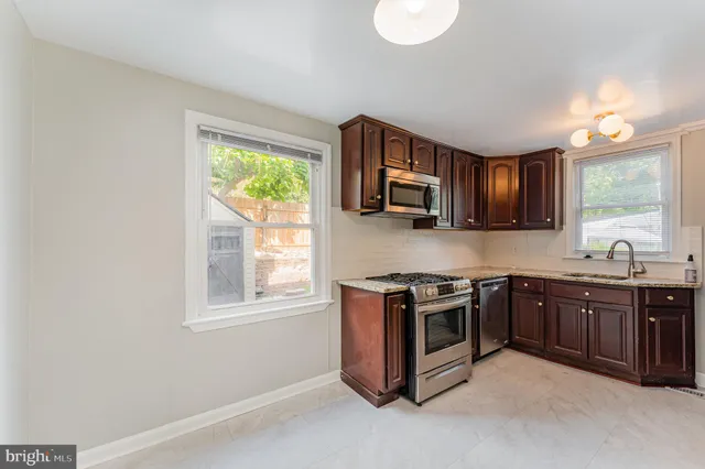 a kitchen with stainless steel appliances granite countertop a stove a sink dishwasher and a microwave