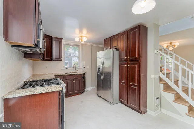 a kitchen with stainless steel appliances granite countertop a refrigerator and a stove