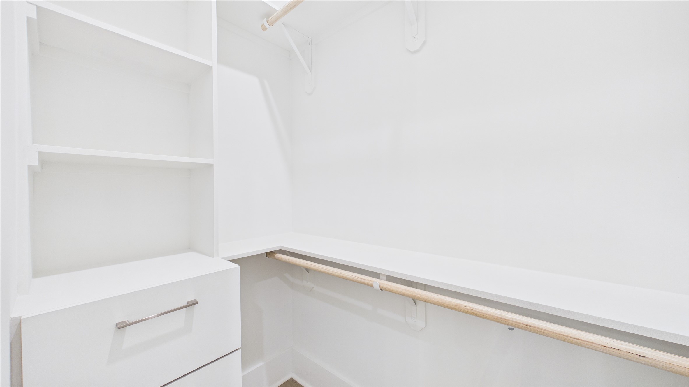 602 Skyland Terrace Way Houston, TX 77009 - Photo 36 of 40 This is a bright, walk-in closet featuring white shelving and hanging rods, providing ample storage space.