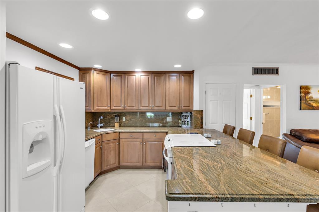 2835 Northeast 28th Avenue, Unit 3 Lighthouse Point, FL 33064 - Photo 14 of 30 a large kitchen with kitchen island a sink stainless steel appliances and cabinets