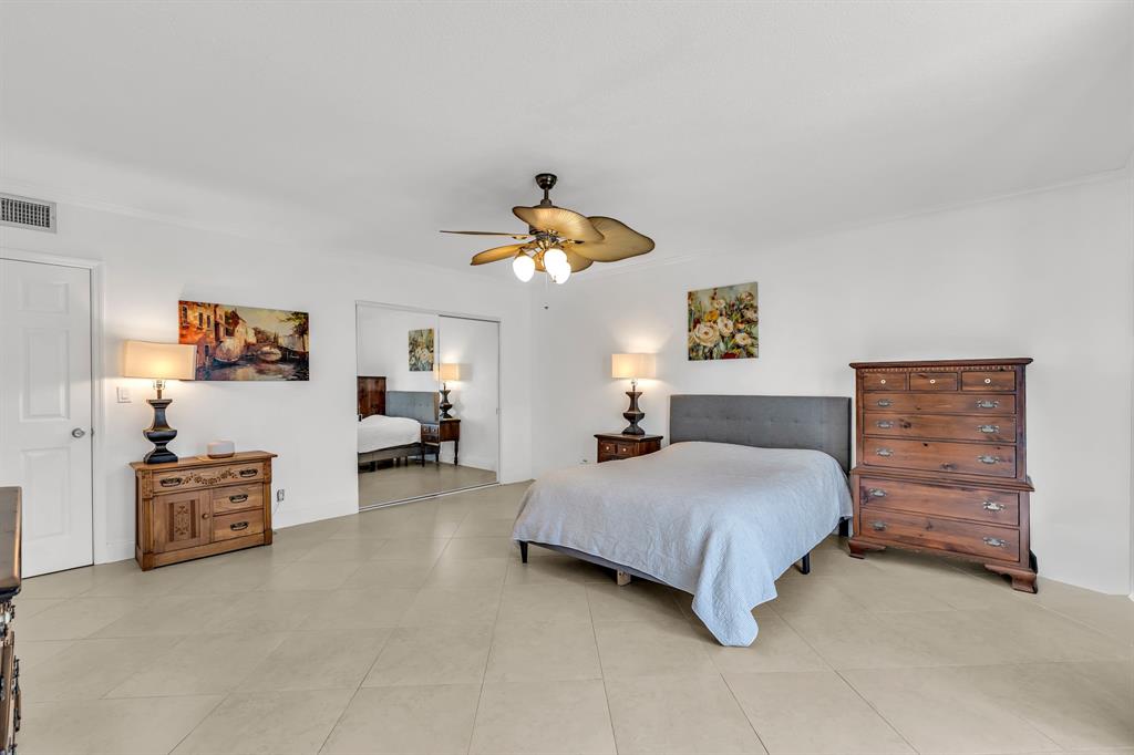 2835 Northeast 28th Avenue, Unit 3 Lighthouse Point, FL 33064 - Photo 17 of 30 a bedroom with a bed and a chandelier