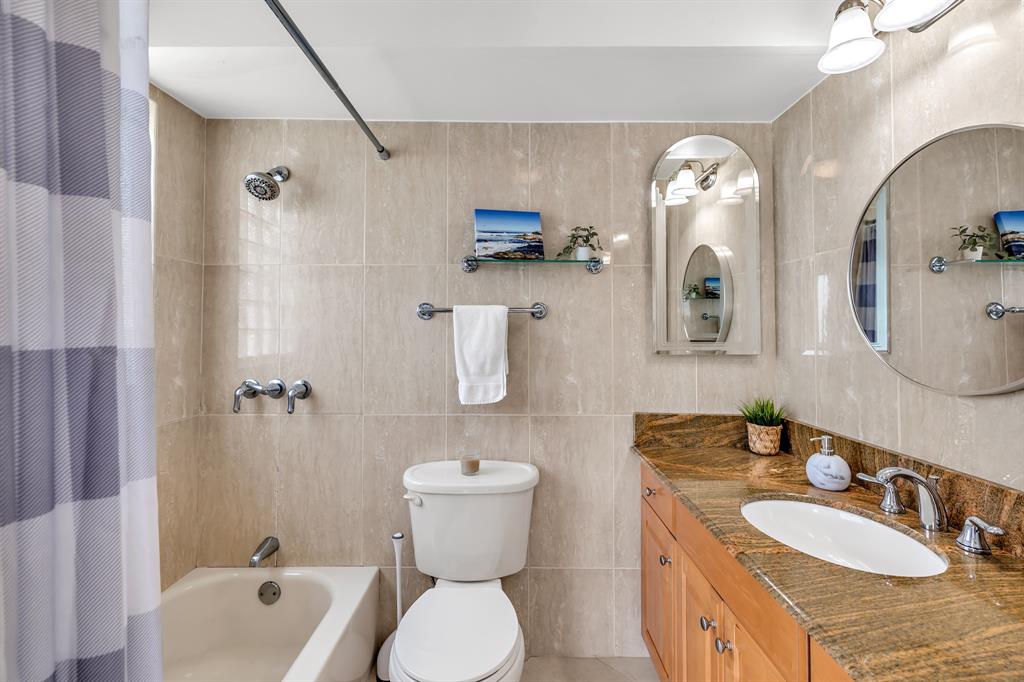 2835 Northeast 28th Avenue, Unit 3 Lighthouse Point, FL 33064 - Photo 21 of 30 a bathroom with a sink a toilet and a mirror