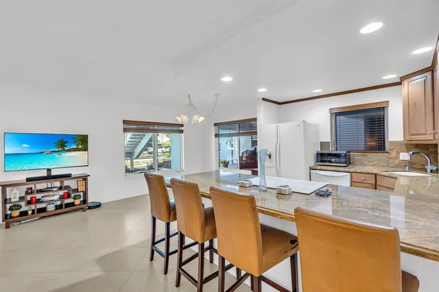 a living room with furniture kitchen view and a window