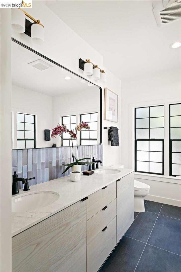 1668 Arch Street Berkeley, CA 94709 - Photo 33 of 78 Dual vanity with integrated sinks, white countertop, and wood-finish cabinetry